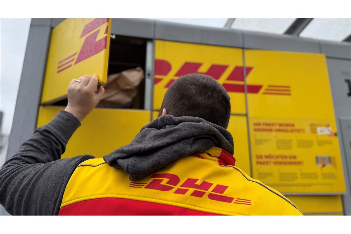 DHL will Anzahl der Paketautomaten bis 2030 verdoppeln Ein Paketbote von DHL steht an einer Packstation, um diese mit Paketen zu befüllen (Symbolbild).