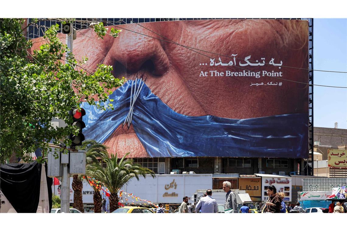 Ein Plakat in Teheran – US-Präsident Trump mit einem Stoffstück in der Form der Straße von Hormus vor dem zugenähten Mund