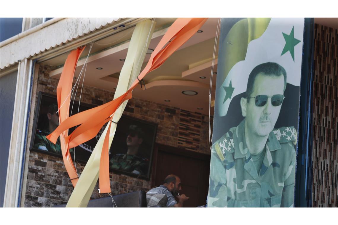 Syriens Machthaber plant Gegenoffensive Ein Plakat zeigt den syrischen Präsidenten Assad vor einem zerbrochenen Fenster in der Provinz Hama in Zentralsyrien.