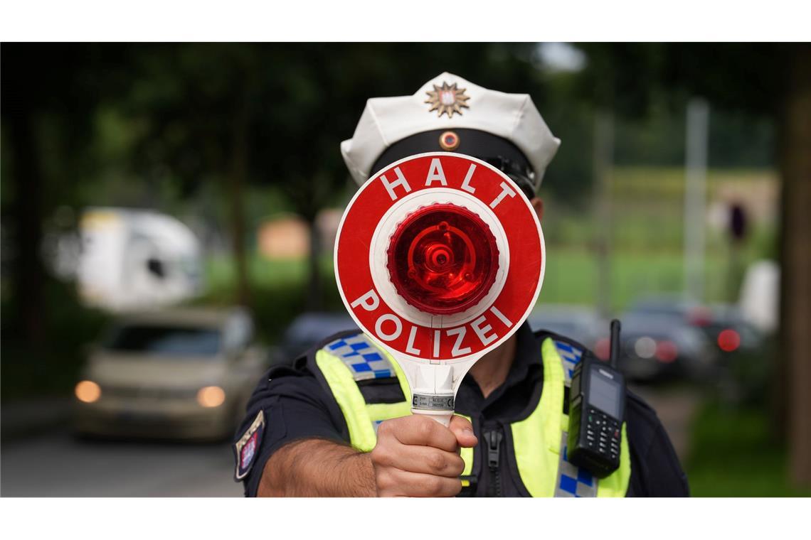 Bilder des Tages Ein Polizeibeamter hält einen Anhaltestab in einer 30er-Zone während des Blitzermarathons im Stadtteil Wilhelmsburg.