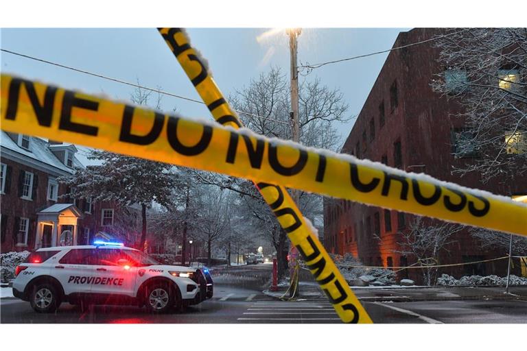 Ein Polizeifahrzeug steht in Providence, R.I., an einer Kreuzung in der Nähe eines abgesperrten Tatorts an der Brown University.