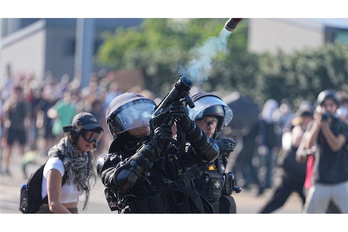 Ein Polizist in Schutzausstattung feuert bei den Protesten gegen den G7 Gipfel in Evian in Frankreich etwas in die Luft. Die Demonstrationen finden in der auf der Schweizer Seite des Genfersee gelegenen Stadt Genf statt.
