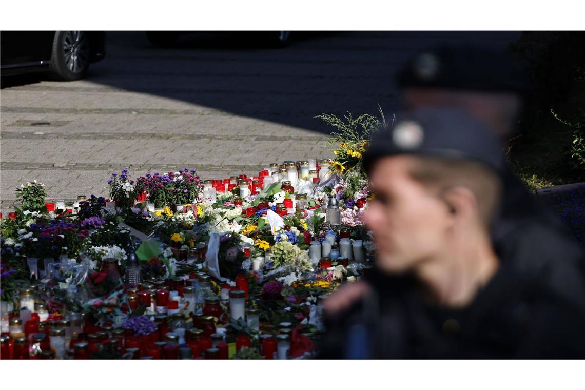 Ein Polizist steht vor einem Blumen, die Menschen abgelegt haben, um der drei Todesopfer eines Anschlags aus dem August 2024 zu gedenken. (Archivbild)