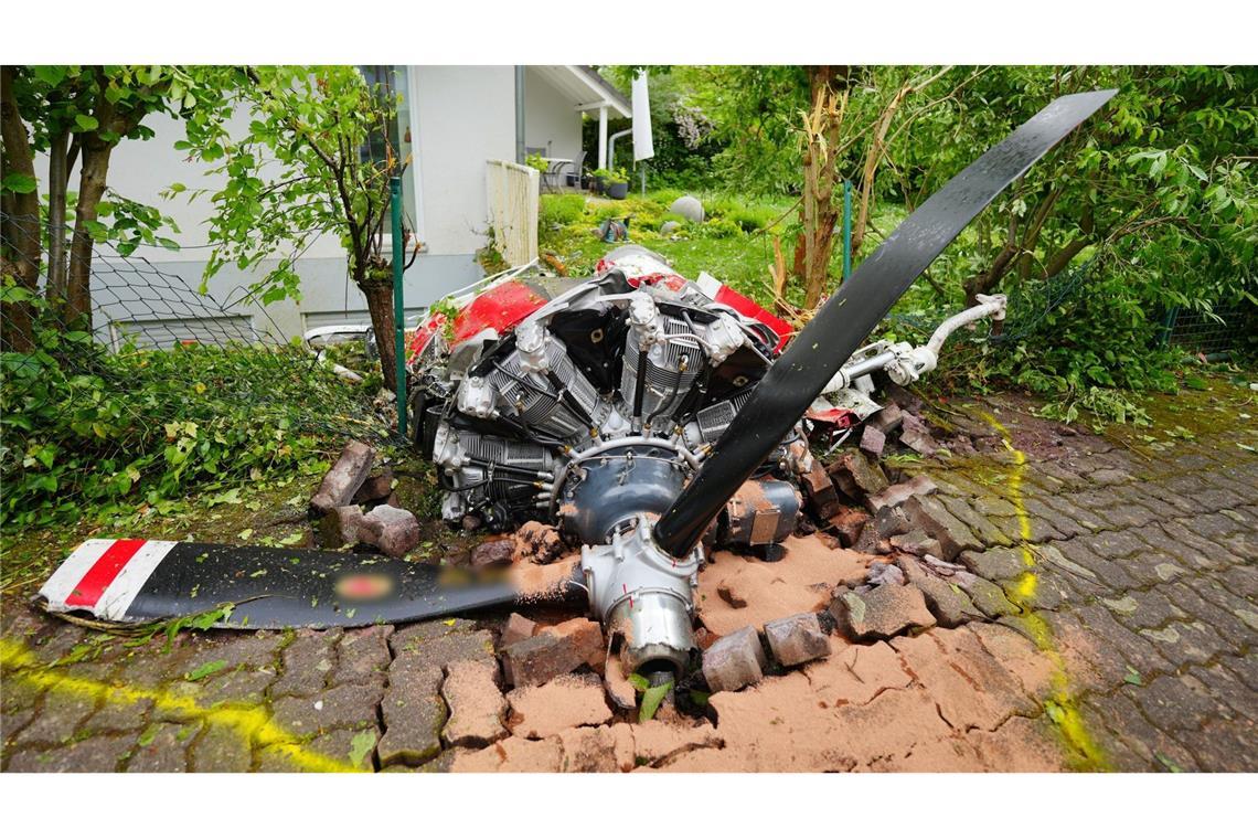 Ein Propeller der Maschine liegt vor einem Wohnhaus.