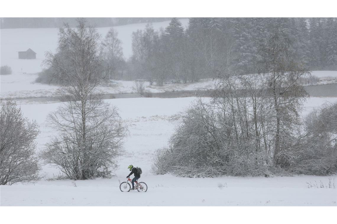 Bilder des Tages Ein Radfahrer fährt durch die schneebedeckte Landschaft in Bayern.
