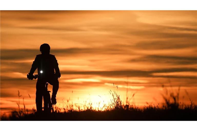 Ein Radfahrer ist im Sonnenaufgang unterwegs.