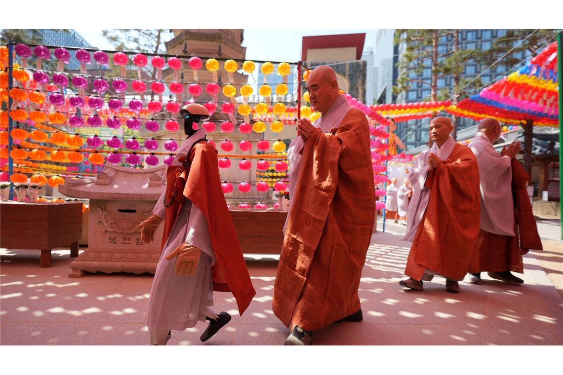Ein Roboter und buddhistische Mönche umrunden zusammen eine Pagode während einer Zeremonie vor dem Geburtstag Buddhas im koreanischen Seoul.