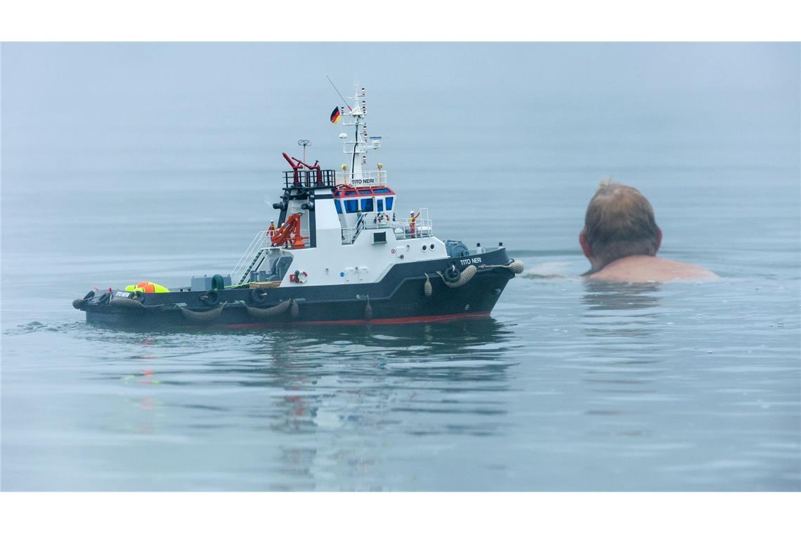 Bilder des Tages Ein Schwimmer und ein Modellboot in Form eines Schleppers sind im Nebel im Schwarzachtalsee unterwegs.
