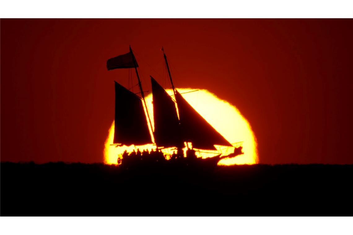 Bilder des Tages Ein Segelboot zeichnet sich gegen die untergehende Sonne ab, während es im Golf vor der Küste von Treasure Island in Florida segelt.