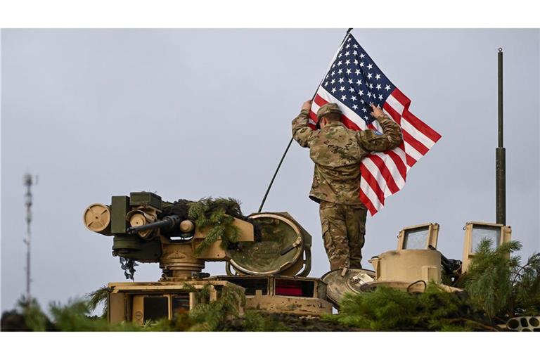 Ein Soldat bringt während der Militärübung «Iron Wolf II» auf dem Truppenübungsplatz Pabrade eine US-amerikanische Fahne an einem Militärfahrzeug an. (Archivbild)