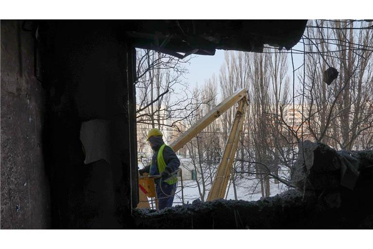 Ein städtischer Arbeiter benutzt eine Hubarbeitsbühne an einem Gebäude, das durch einen nächtlichen russischen Drohnenangriff beschädigt wurde.