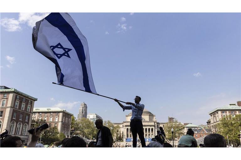 Ein Student an der Columbia University schwenkt eine große israelische Flagge.  Die US-Regierung streicht der renommierten Columbia-Universität in New York Fördergelder in Millionenhöhe.