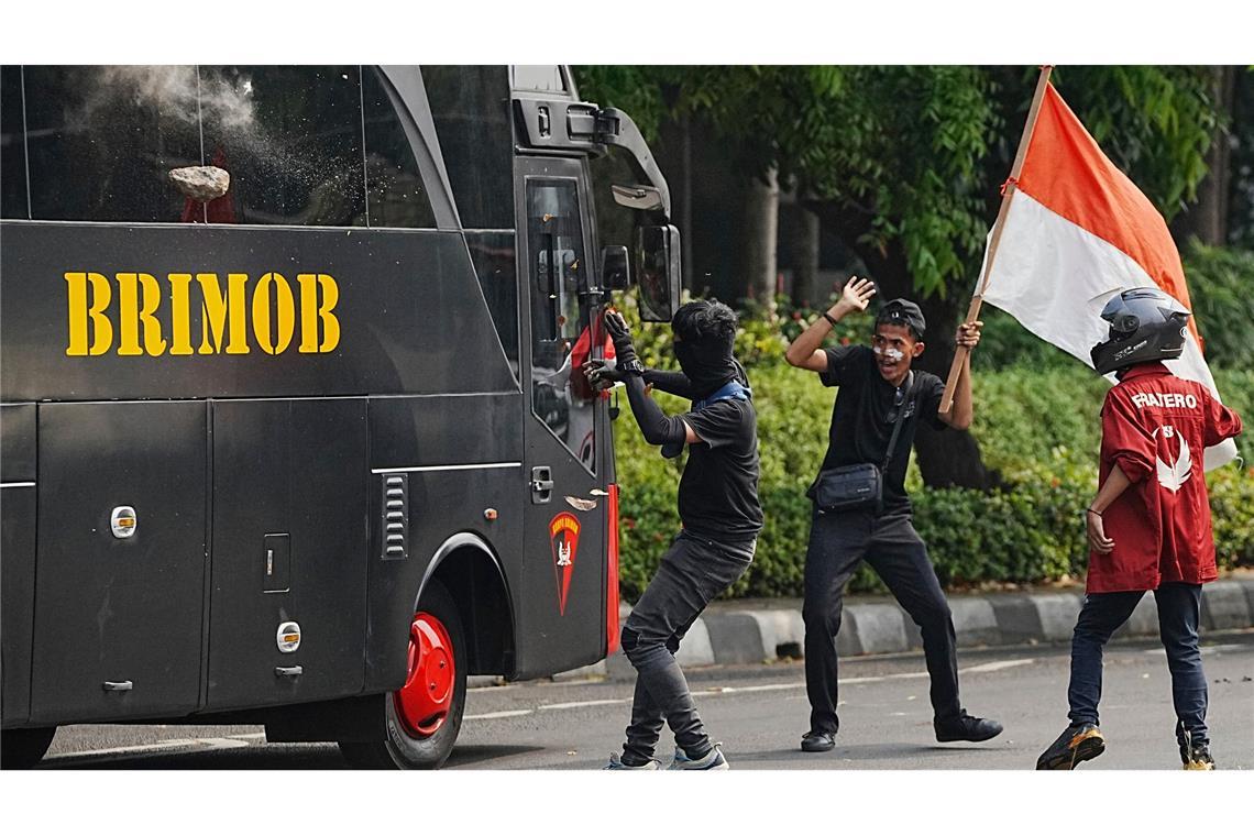 Ein Student wirft einen Stein auf ein Polizeifahrzeug bei gewalttätigen Protesten gegen üppigen Zulagen für Parlamentsmitglieder in Indonesien.