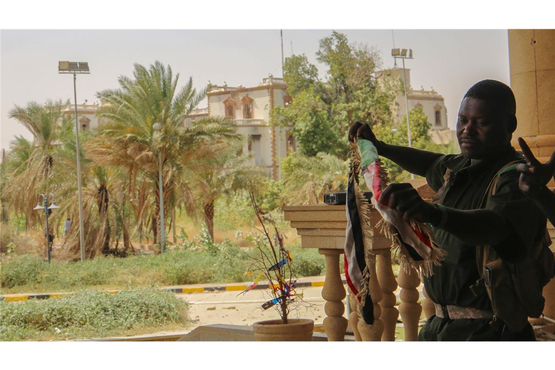 Sudans Regierungstruppen erobern Präsidentenpalast zurück Ein sudanesischer Soldat mit der Nationalfahne nach der Rückeroberung des Präsidentenpalasts in Khartum