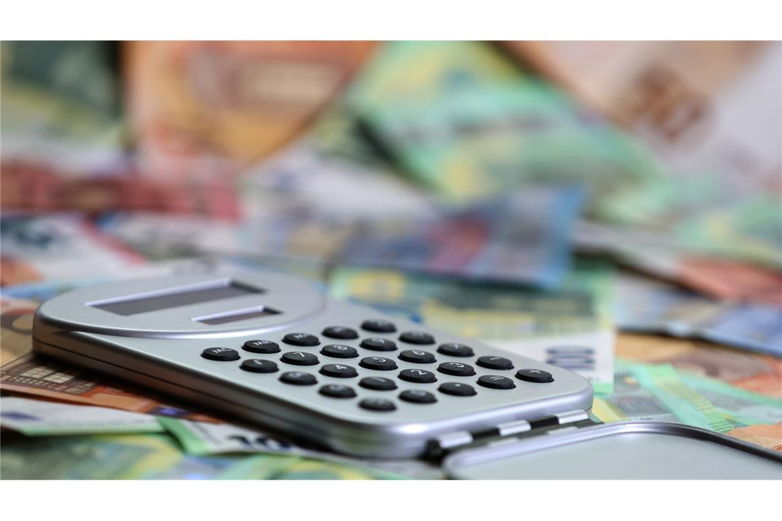 Ein Taschenrechner liegt auf verschiedenen Euro-Banknoten. (Symbolbild)