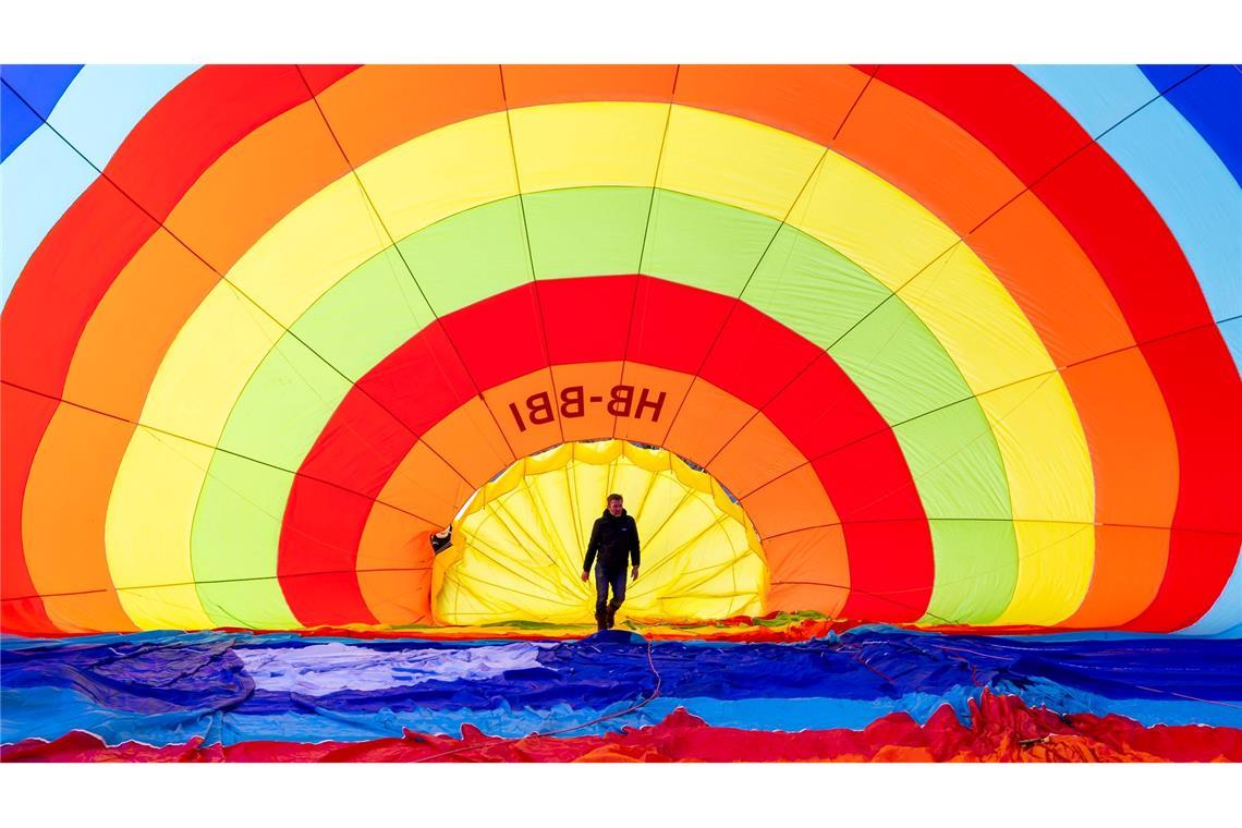 Ein Teammitglied überprüft seinen Heißluftballon vor dem Start während des 46. Internationalen Heißluftballon-Festivals in Chateau-d'Oex.
