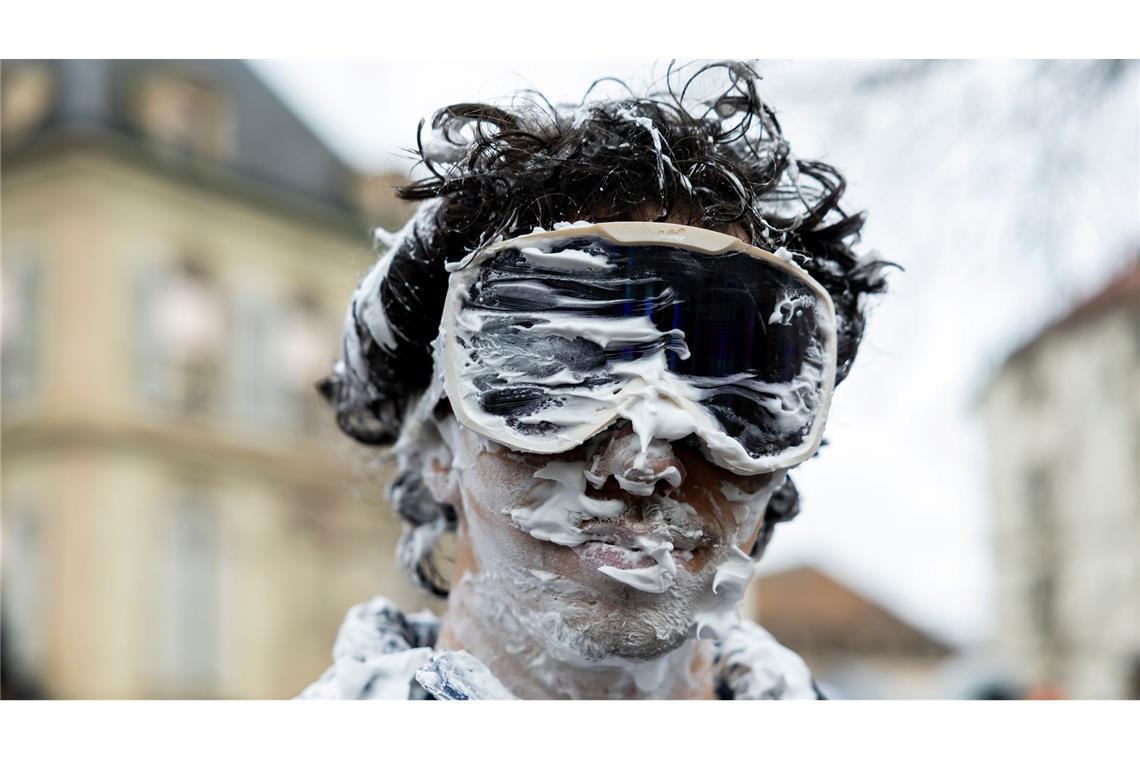 Ein Teilnehmer ist beim "Picoulet" in Genf verkleidet und voller Rasierschaum. Bei dem traditionellen bunten Umzug mit Musik kommt es oft zu wahren Schaumschlachten.