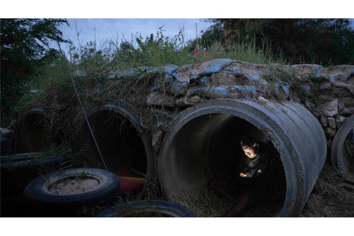 Ein thailändischer Einwohner, der vor Zusammenstößen zwischen thailändischen und kambodschanischen Soldaten geflohen ist, benutzt sein Mobiltelefon, während er in der thailändischen Provinz Buriram Schutz sucht.