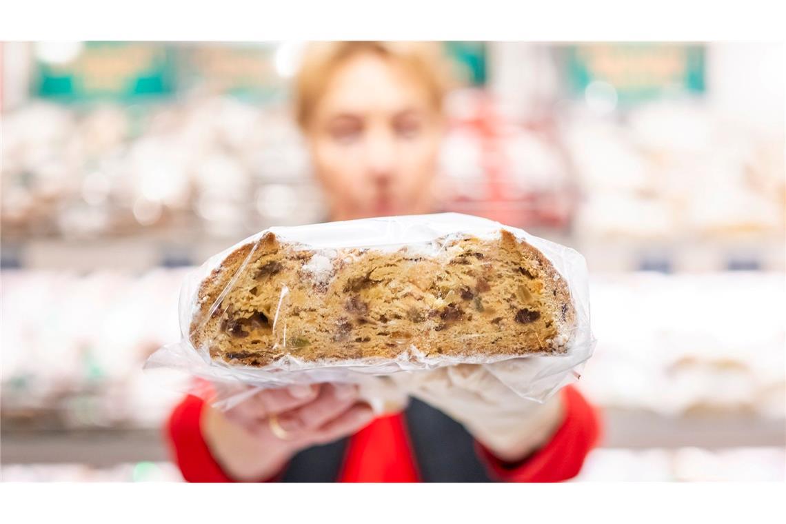 Bilder des Tages Ein Verkäuferin präsentiert auf dem Erfurter Weihnachtsmarkt einen Stollen.