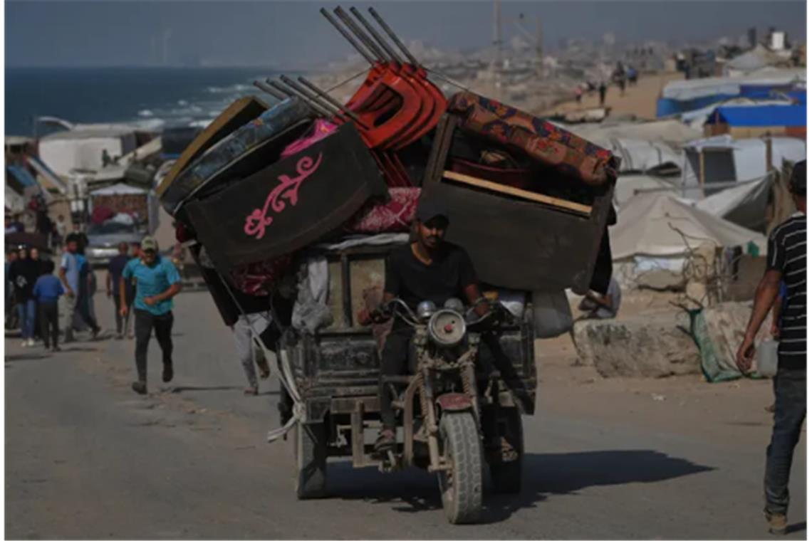 Ein vertriebener Palästinenser flieht aus dem nördlichen Gazastreifen und trägt seine Habseligkeiten auf seinem Dreirad entlang der Küstenstraße in der Nähe von Wadi Gaza (Archivbild).