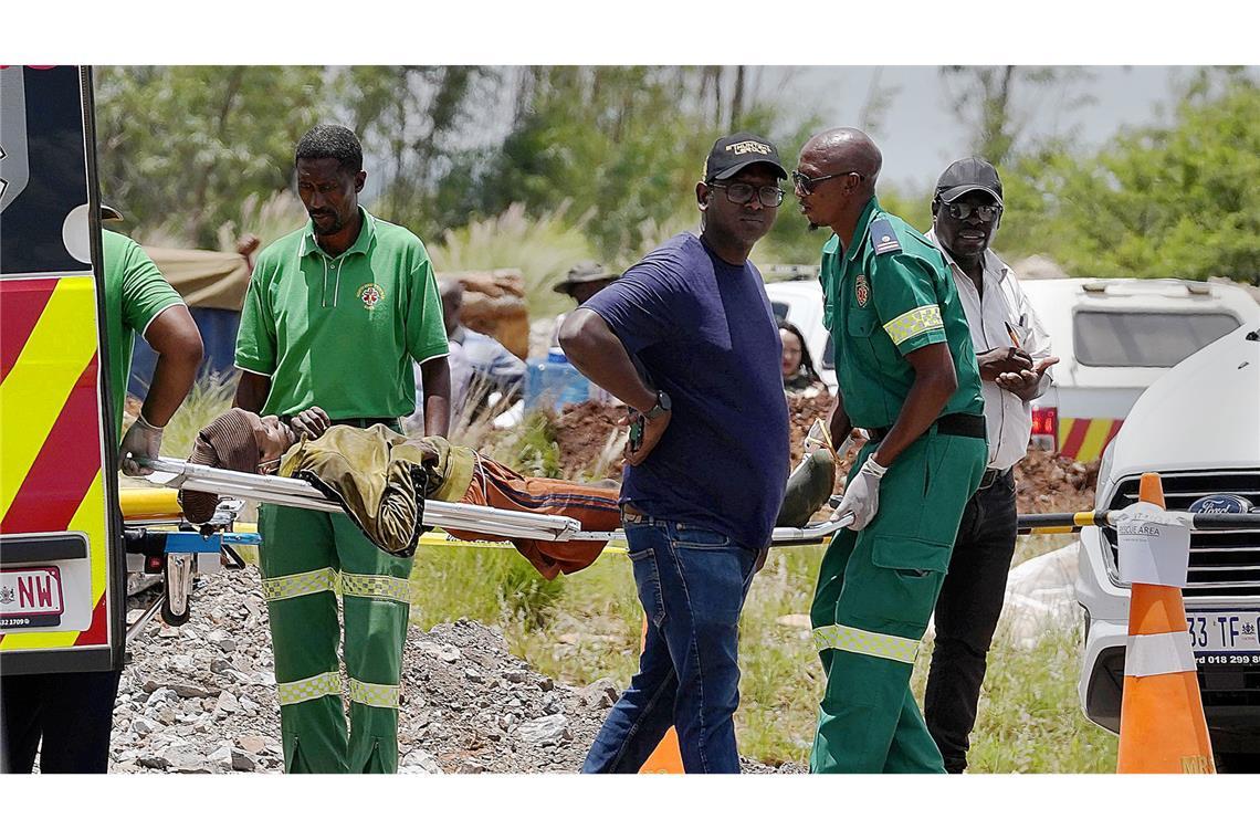 Massensterben unter Tage Ein völlig entkräfteter Bergarbeiter wird von Rettungskräften auf einer Trage transportiert, nachdem er aus der Goldmine gerettet wurde.