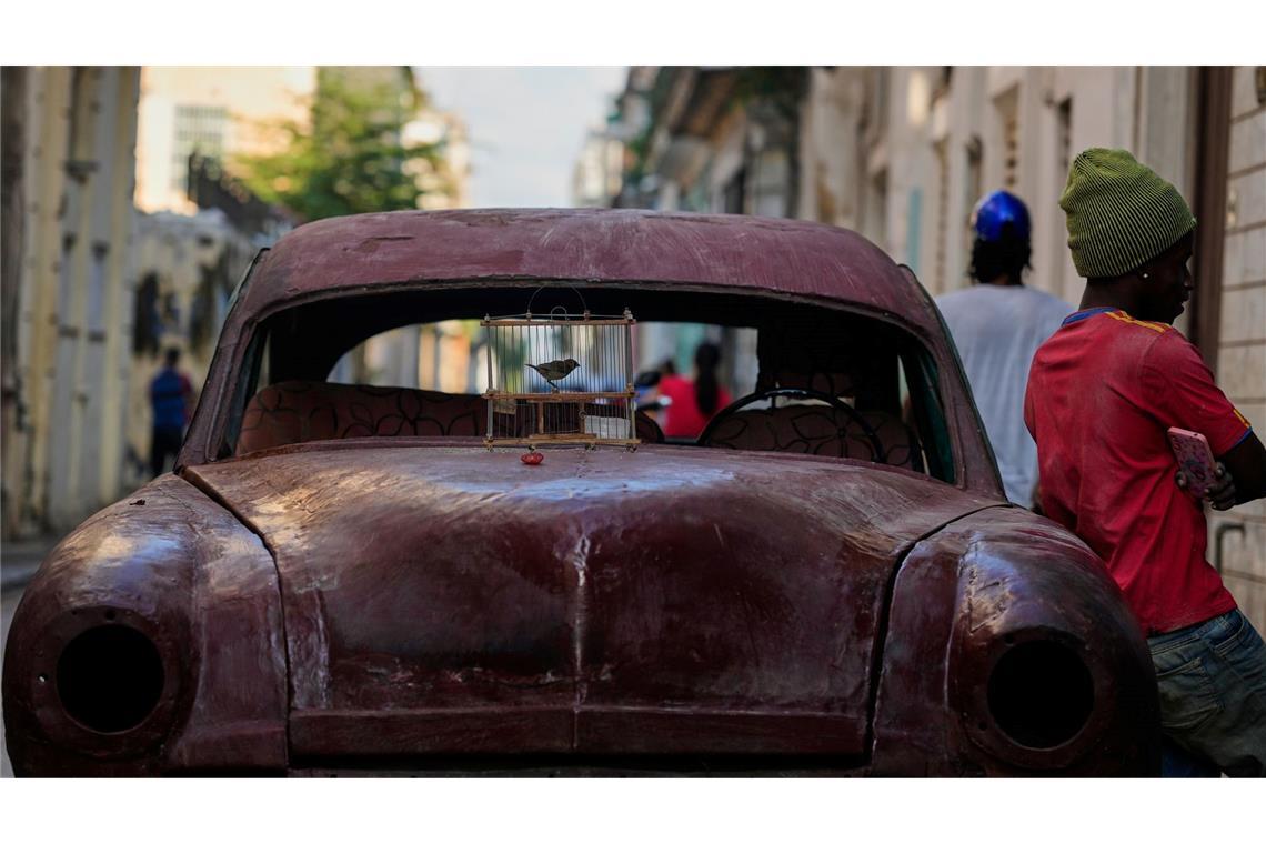 Ein Vogel in einem Käfig steht in Havanna zum Verkauf auf der Motorhaube.