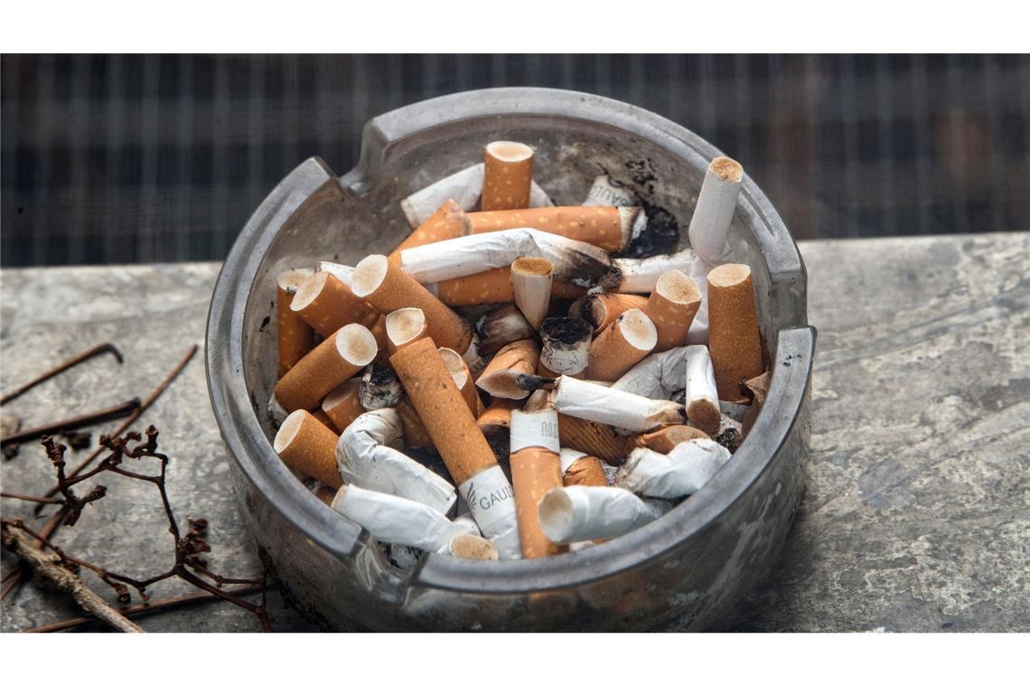 Ein voller Aschenbecher steht auf einem Fensterbrett.