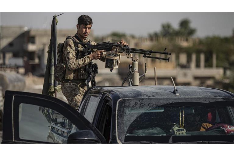 Ein von den USA unterstützter Kämpfer der Syrischen Demokratischen Kräfte (SDF) steht auf einem gepanzerten Fahrzeug in Ostsyrien. Bei Kämpfen im Westen Syrien starben drei Menschen (Archivfoto).