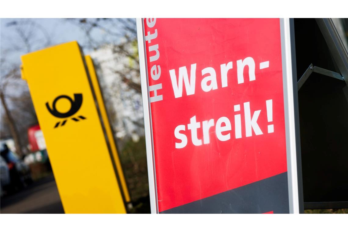 Post-Warnstreiks: Jeder zehnte Brief bleibt vorerst liegen Ein Warnstreik-Schild bei einem Post-Standort, daneben ein Briefkasten - im Ringen um einen Tarifabschluss haben Tausende Postler erneut die Arbeit niedergelegt.