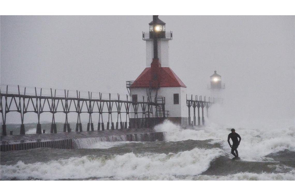 Ein Wellenreiter surft durch wehenden Schnee.