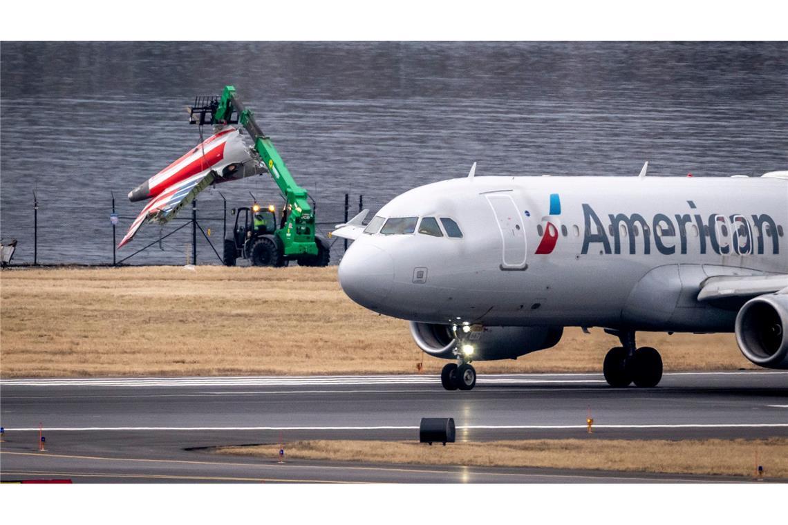 Bilder des Tages Ein Wrackteil wird am Potomac River auf einen Truck geladen, während ein Flugzeug vom Ronald Reagan Washington National Airport abhebt.