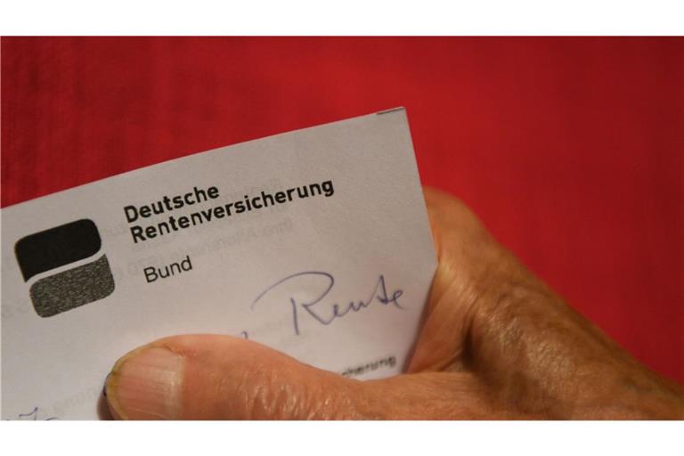 Eine ältere Frau hält ihren Rentenbescheid in der Hand.