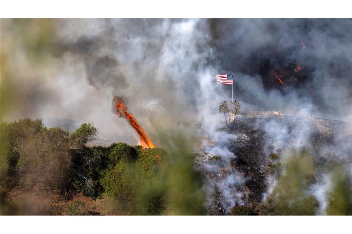 Trump ätzt über Brandbekämpfung - 16 Tote bei Feuern in LA Eine amerikanische Flagge weht über einem Teil des Mandeville Canyon