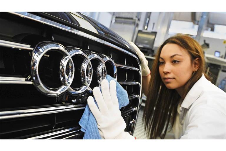 Eine Audi-Mitarbeiterin poliert in Neckarsulm die Audi-Ringe an einer A8-Limousine. Die Zukunft des Werks ist gefärhdet.
