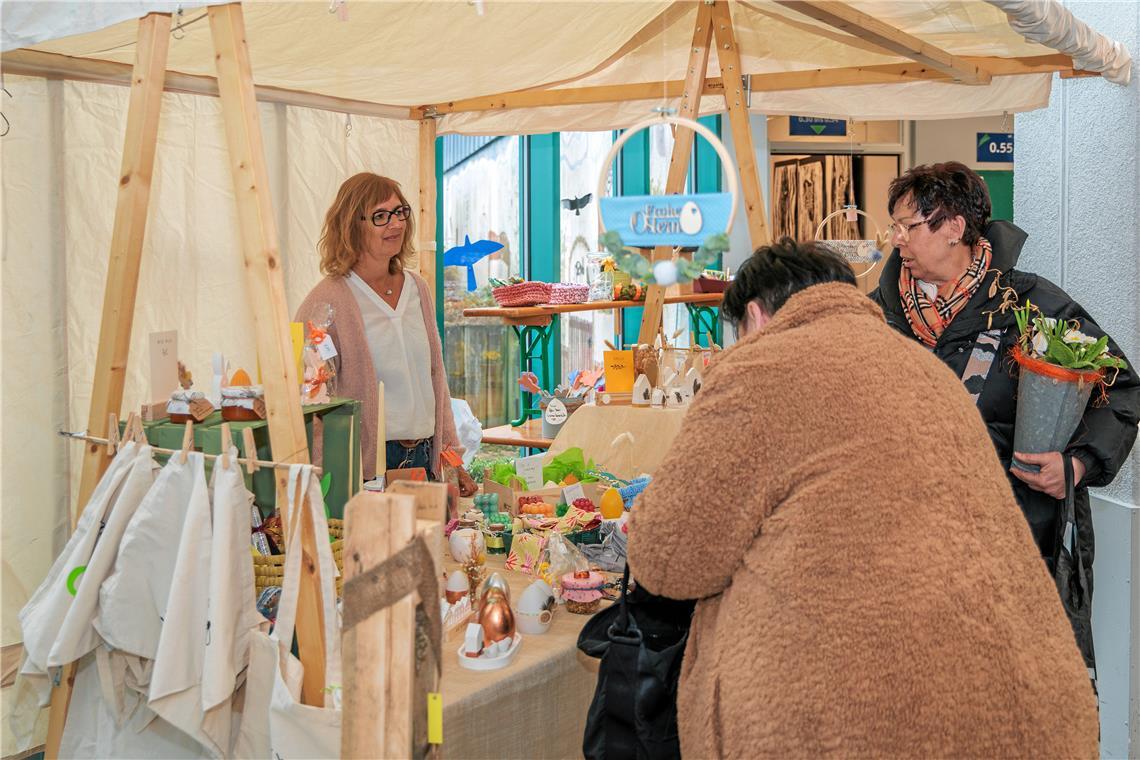 Blumen, Osterschmuck und Begegnungen Eine Besucherin ist an einem Stand voller österlicher Deko fündig geworden. Foto: Stefan Bossow