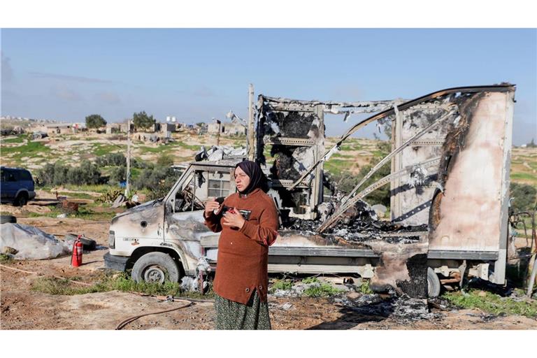 Eine Bewohnerin steht neben einem ausgebrannten Fahrzeug im Dorf Susya bei Hebron im besetzten Westjordanland. Israelische Siedler sollen Ende Februar dort Zelte und Autos angezündet haben.