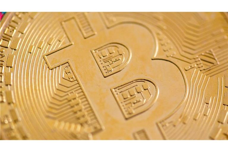 Eine Bitcoin-Münze liegt auf einem Tisch. (Symbolbild)