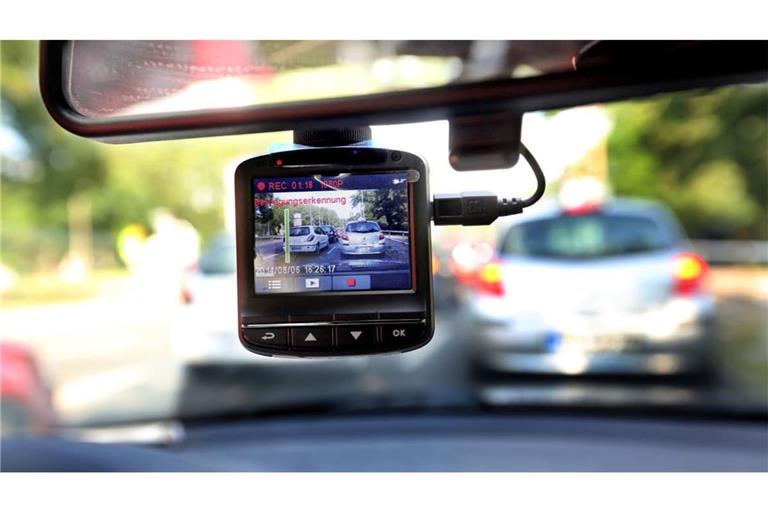 Eine Dashcam, befestigt an der Windschutzschreibe, filmt den Straßenverkehr aus einem Auto.