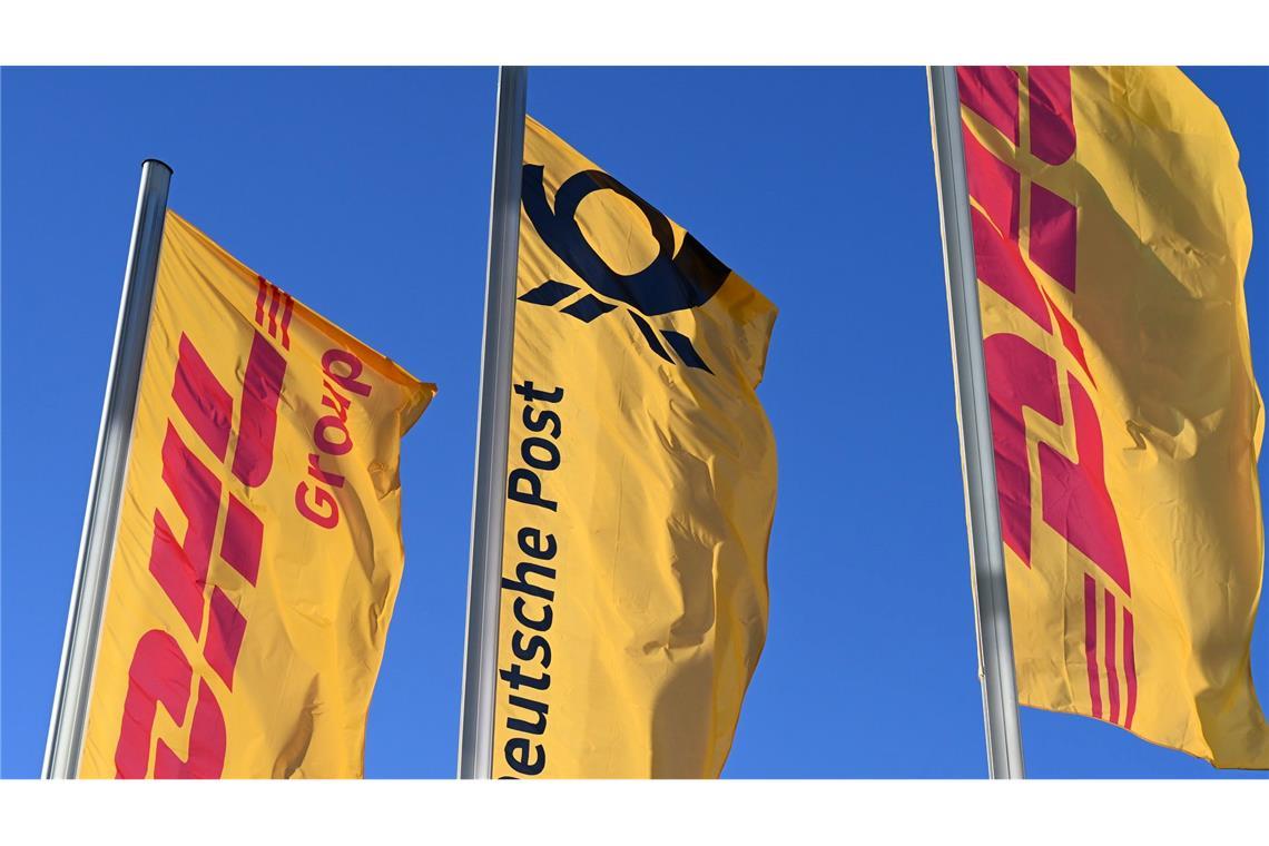 Eine Deutsche-Post-Fahne an der Konzernzentrale, umrahmt von DHL-Fahnen.
