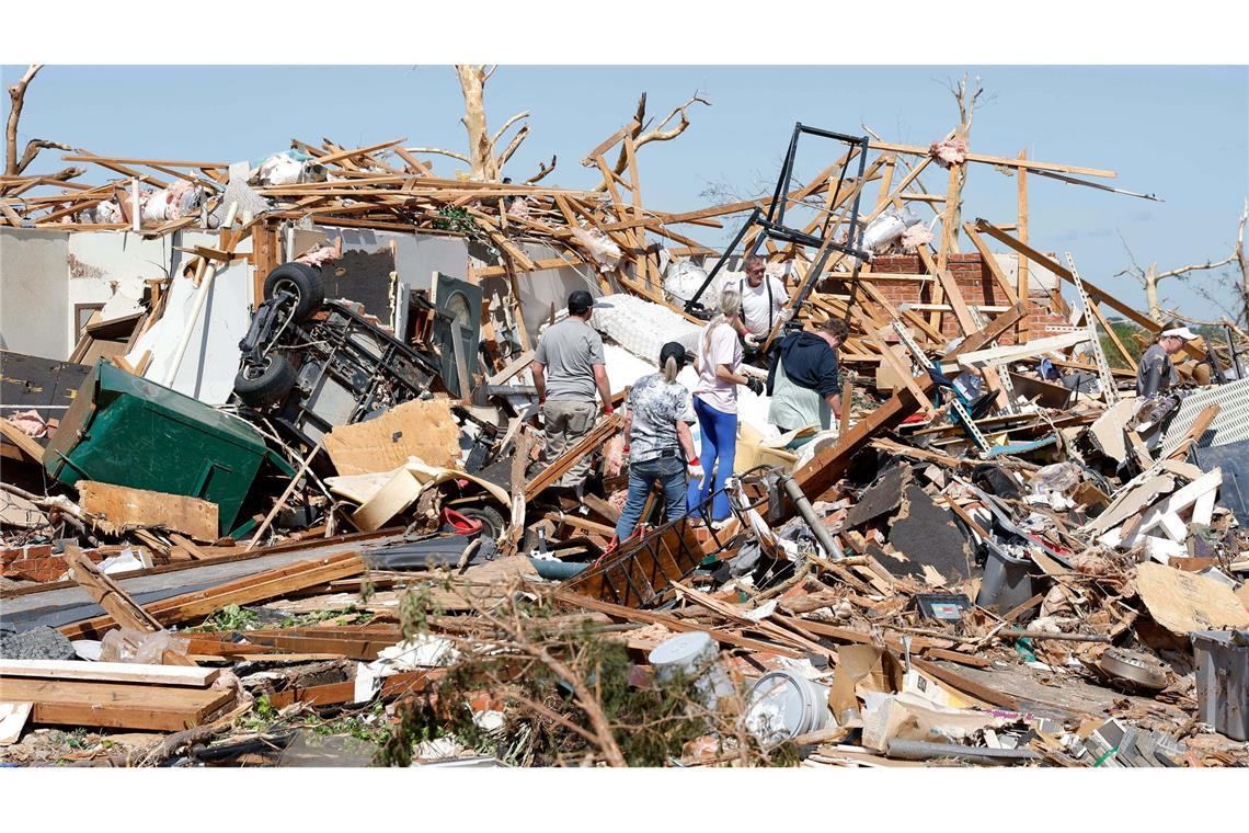 Eine Familie blickt nach einem Tornado durch die Trümmer ihres Hauses im Stadtteil Grayridge in Oklahoma.