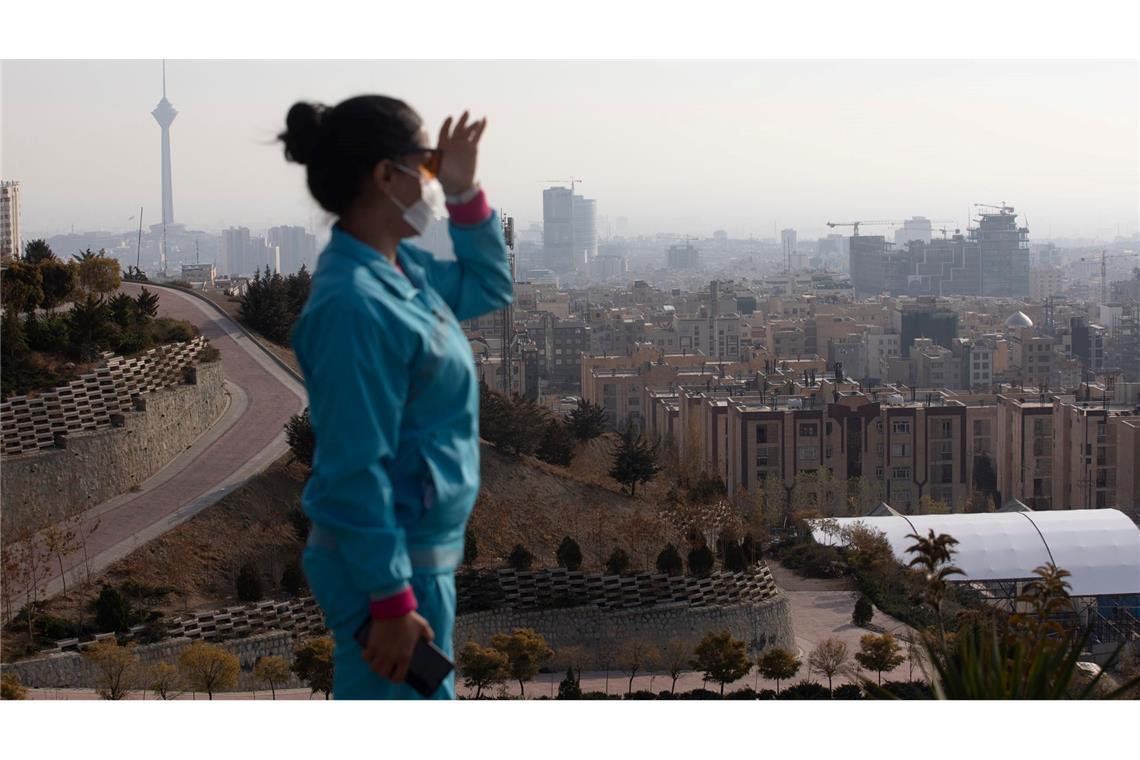 Eine Frau blickt auf die von Smog geplagte Millionenmetropole Teheran.