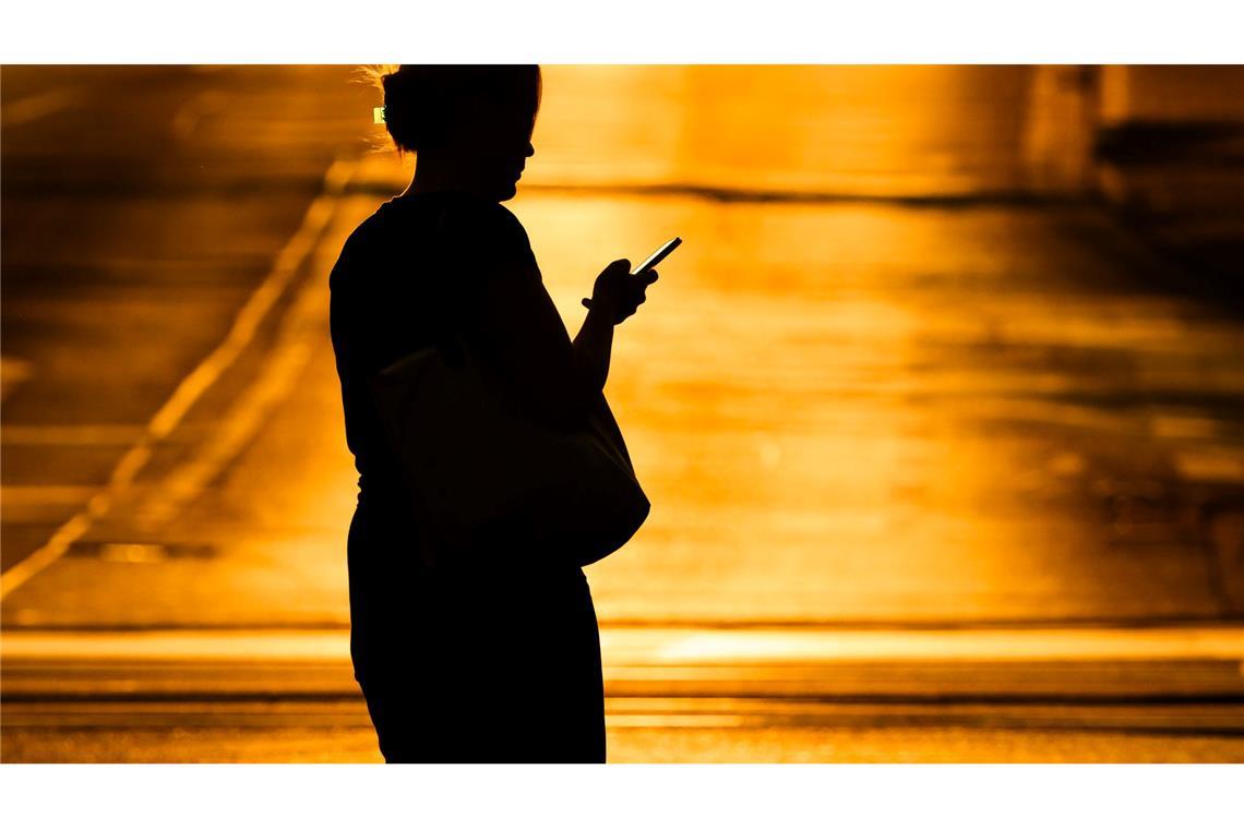 Catfishing-Doku weltweit ein Streaming-Hit Eine Frau mit Handy - in der Netflix-Doku "Unbekannte Nummer: Der Highschool-Catfish" kommt der Psychoterror via Smartphone. (Symbolbild)