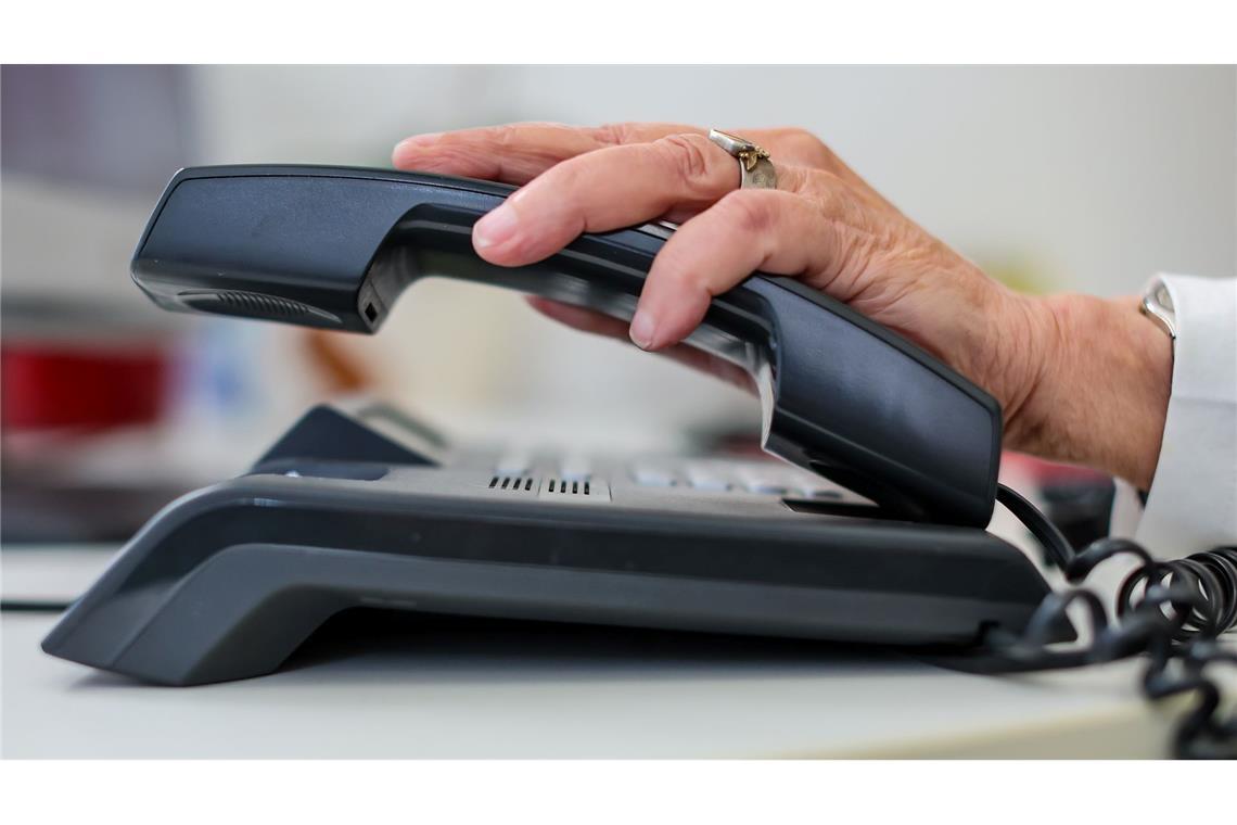 Ende von Call-by-Call: Billig-Vorwahlen fallen weg Eine Frau nimmt einen Telefonhörer in die Hand.