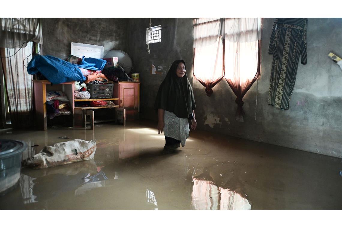 Eine Frau steht nach heftigen Monsun-Regenfällen in Indonesien in ihrem überfluteten Haus