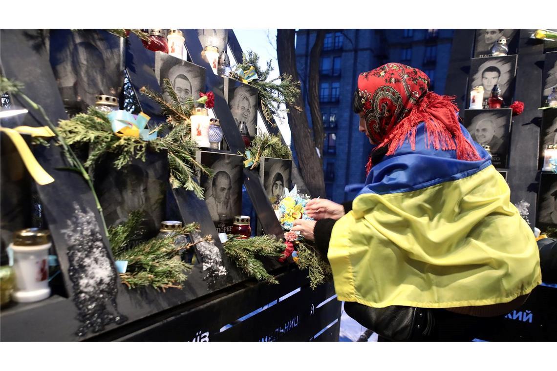 Trump setzt US-Schützling Ukraine unter Druck Eine Frau trauert in Kiew um Gefallene.