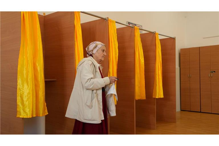 Eine Frau verlässt die Wahlkabine, nachdem sie ihre Stimme in der ersten Runde der Präsidentschaftswahlen in Bukarest, Rumänien, abgegeben hat.