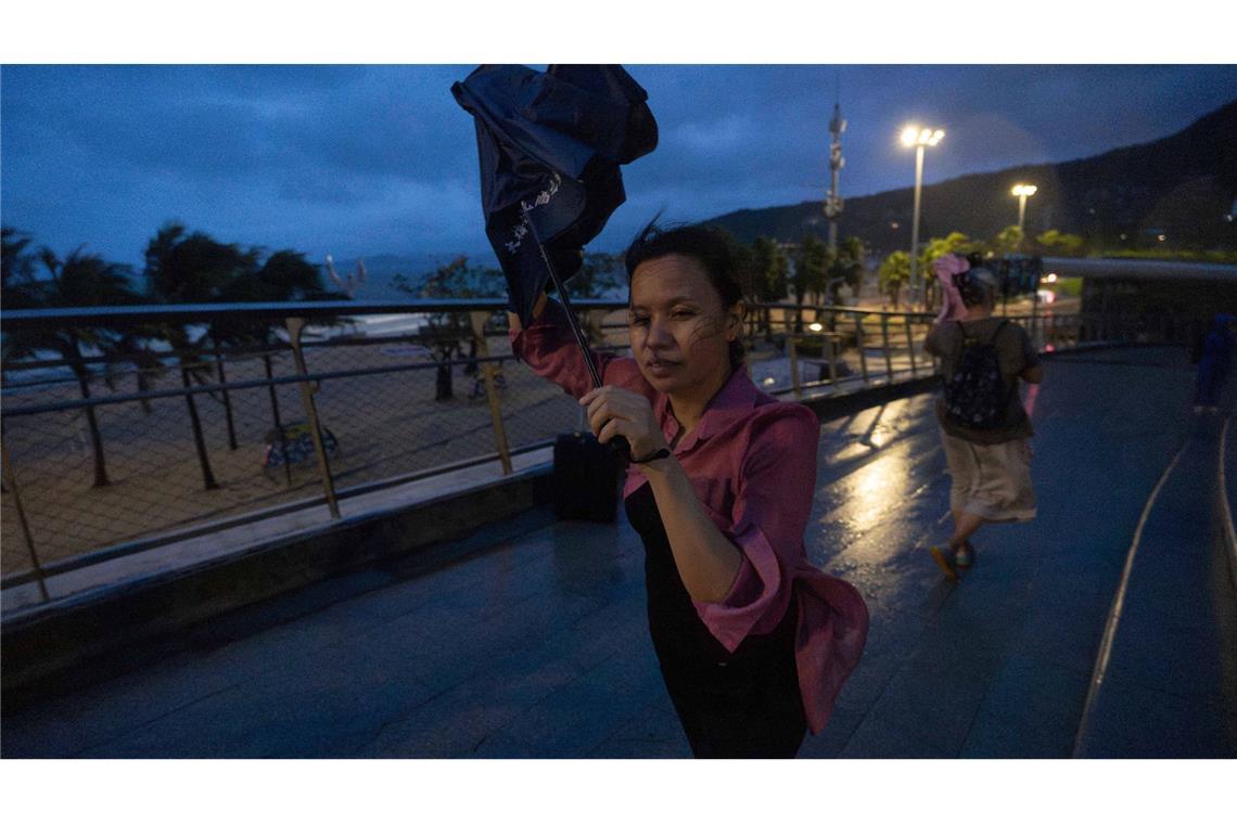 Bilder des Tages Eine Frau versucht, nach dem Super-Taifun Ragasa in Shenzhen in der südchinesischen Provinz Guangdong einen Regenschirm im Wind zu öffnen.