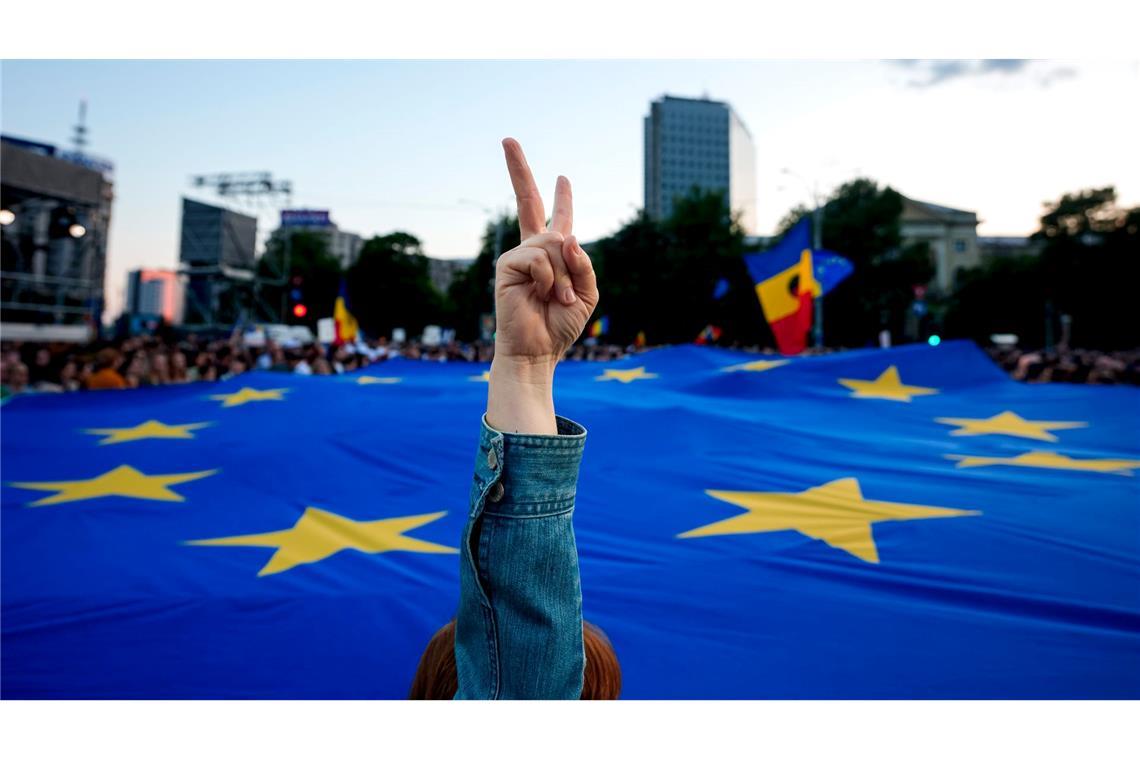 Eine Frau zeigt ein Siegeszeichen mit der Flagge der Europäischen Union im Hintergrund während einer Wahlkampfveranstaltung des rumänischen Präsidentschaftskandidaten Dan, eine Woche vor der zweiten Runde der Präsidentschaftswahlen.