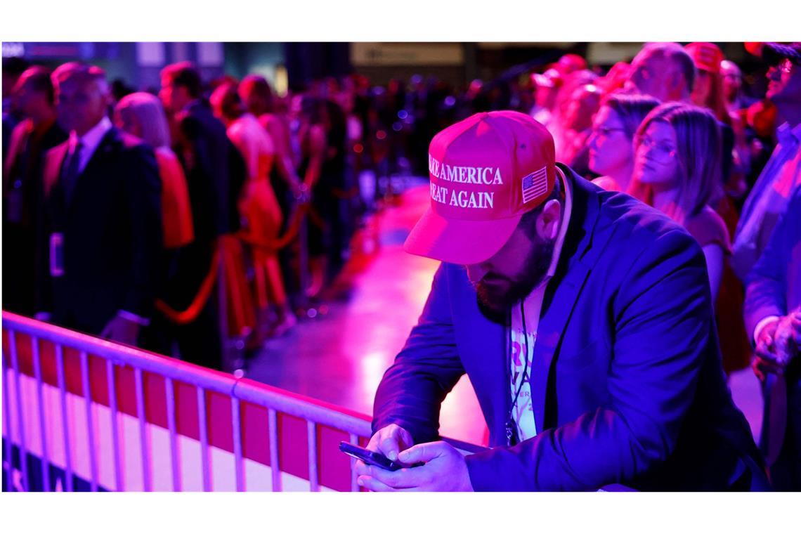 Verzweiflung hier, Euphorie da – Bilder einer Wahlnacht Eine Nervenprobe: Bei einer Wahlparty in Florida checkt ein Donald-Trump-Fan die neuesten Nachrichten auf seinem Handy.