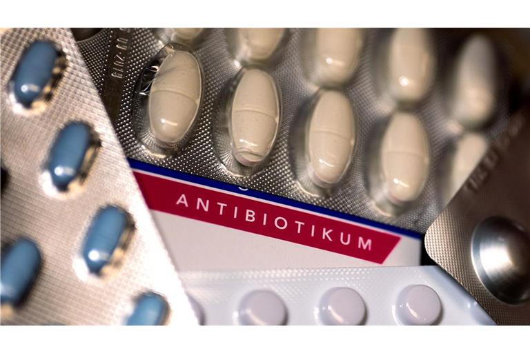 Eine Packung Antibiotika und diverse andere Medikamente liegen auf einem Tisch in einer Apotheke.